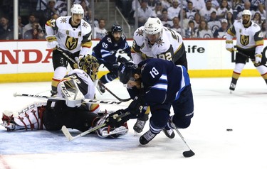 Winnipeg Jets centre Bryan Little is dumped by Vegas Golden Knights forward Tomas Nosek in front of goaltender Marc-Andre Fleury during Game 2 of the Western Conference final in Winnipeg on Mon., May 14, 2018. Kevin King/Winnipeg Sun/Postmedia Network