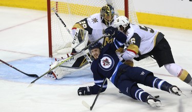 Winnipeg Jets forward Jack Roslovic is dumped by Vegas Golden Knights forward Erik Haula in front of goaltender Marc-Andre Fleury during Game 5 of the Western Conference final in Winnipeg on Sun., May 20, 2018. Kevin King/Winnipeg Sun/Postmedia Network