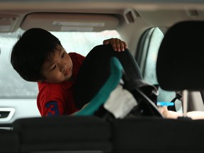 Caleb James Marquez, 2, is an interested observer during CAA Manitoba's first car seat inspection clinic at its St. Anne's Road store in Winnipeg on Sunday.