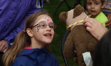 Leilani Bergen, 7, watches as Teddy has glasses fitted during the 32nd annual Teddy Bears' Picnic, in support of the Children's Hospital Foundation of Manitoba, at Assiniboine Park in Winnipeg on Sun., May 27, 2018. Kevin King/Winnipeg Sun/Postmedia Network