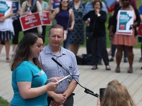 Kimberly Grey, from the Manitoba Government Employees Union home care section, speaks with Kevin Rebeck, president of the Manitoba Federation of Labour, at her side during a rally for public services on the Manitoba Legislative Building grounds in Winnipeg on Sun., May 27, 2018. Kevin King/Winnipeg Sun/Postmedia Network