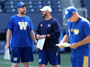 Head coach Mike O'Shea (left) speaks with quarterbacks coach Buck Pierce during Blue Bombers training camp.