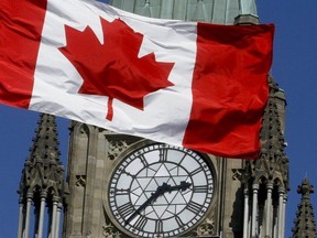 A Canadian flag from West Block on Parliament Hill waves in front of the Peace Tower, in Ottawa on Mar. 24, 2011. (Chris Roussakis/Postmedia Network)
