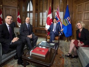 Prime Minister Justin Trudeau speaks before a meeting on the deadlock over Kinder Morgan's Trans Mountain pipeline expansion with B.C. Premier John Horgan, second from left, and Alberta Premier Rachel Notley, as Minister of Finance Bill Morneau looks on, in Trudeau's office on Parliament Hill in Ottawa on Sunday, April 15, 2018.