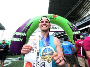Corey Gallagher shows off his finisher medal after winning the men's full marathon at the 40th annual Manitoba Marathon on Sunday. Gallagher crossed the finish line in a time of 2:37:47.6.