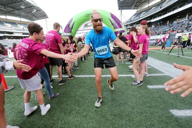 Tyler Bargen of Winnipeg has fun by giving high fives after finishing the men's half marathon at the 40th annual Manitoba Marathon in Winnipeg, Man., on Sunday, June 17, 2018. Bargen crossed the finish line in the 13.1 mile race in a time of 1:33:59.2. (Brook Jones/Postmedia Network)