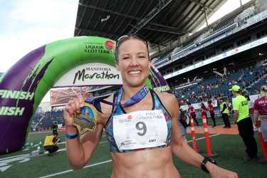 Amy Feit from Luverne, Minnesota shows off her finisher medal after winning the women's full marathon at the 40th annual Manitoba Marathon in Winnipeg, Man., on Sunday, June 17, 2018. Feit crossed the finish line in the 26.2 mile race in a time of 3:02:50.3. (Brook Jones/Postmedia Network)