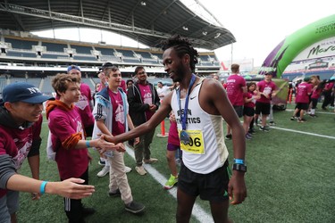 Abduselam Yussuf of Winnipeg gives high fives after winning the men's half marathon at the 40th annual Manitoba Marathon in Winnipeg, Man., on Sunday, June 17, 2018. Yussuf crossed the finish line in the 13.1 mile race in a time of 1:08:30.0. (Brook Jones/Postmedia Network)