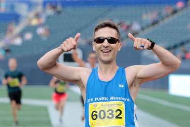 Daniel Thompson, who is from Thompson, gives two thumbs up as he crosses the finish line in the half marathon at the 40th annual Manitoba Marathon in Winnipeg, Man., on Sunday, June 17, 2018. He completed the 13.1 mile course in a time of 1:34:28.4. (Brook Jones/Postmedia Network)
