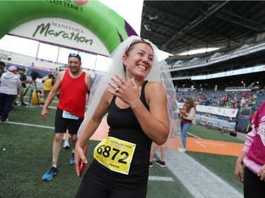 Kristin Darragh of East St. Paul shows off her engagement after crossing the finish line in the half marathon at the 40th annual Manitoba Marathon in Winnipeg, Man., on Sunday, June 17, 2018. Darragh completed the 13.1 mile race while wearing a wedding veil in a time of 2:14:45.8. (Brook Jones/Postmedia Network)