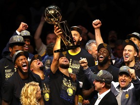 Stephen Curry of the Golden State Warriors celebrates with the Larry O'Brien Trophy after defeating the Cleveland Cavaliers during Game Four of the 2018 NBA Finals at Quicken Loans Arena on June 8, 2018 in Cleveland, Ohio.