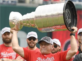 Head coach Barry Trotz of the Washington Capitals raises the Stanley Cup as the team is honored before a baseball game between the Washington Nationals and the San Francisco Giants at Nationals Park on June 9, in Washington, DC.