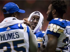 Winnipeg Blue Bombers' Anthony Gaitor, centre, listens while talking with Johnny Augustine, left, and Brandon Alexander on the sideline during the second half of a pre-season CFL football game against the B.C. Lions in Vancouver, on Friday June 8, 2018.
