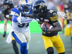 Hamilton Tiger-Cats wide receiver Brandon Banks (16) tries to fend off Winnipeg Blue Bombers defensive back Maurice Leggett (31) during first quarter CFL game action in Hamilton on Friday.
