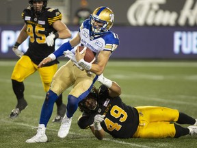 Hamilton Tiger-Cats defensive tackle Nikita Whitlock (49) gets hold of Winnipeg Blue Bombers quarterback Chris Streveler (17) during second half CFL game action in Hamilton on Friday.