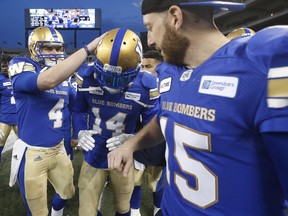 Winnipeg Blue Bombers' Myles White (14) is congratulated for his 80-yard touchdown by quarterbacks Zack Mahoney (4) and Matt Nichols (15) during pre-season CFL action Friday.