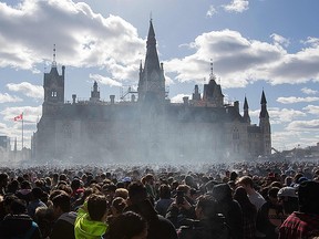 Smoke lingers over Parliament Hill as people smoke marijuana during the annual 4/20 rally on Parliament Hill in Ottawa, Ontario on April 20, 2018. AFP PHOTO