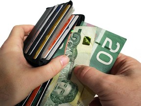 The action of pulling canadian money out of a wallet. ORG XMIT: POS1610071939292809