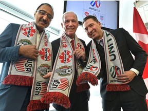 Showing off their soccer bid scarves from left, Amarjeet Sohi, Minister of Infrastructure and Communities, left, Steven Reed, President of Canada Soccer and Co-Chair of the United 2026 Bid Committee and Coun. Michael Walters after announcing that Edmonton has been named as a host city for the 2026 FIFA World Cup that would take place in Canada, Mexico and United States, at Commonwealth Stadium in Edmonton, March 16, 2018.