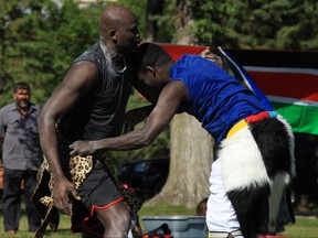 Mach Agor (left) and James Nak, members of the South Sudanese Canadian Traditional Wrestling Association participate in a traditional South Sudanese wrestling match in Kildonan Park in Winnipeg on Saturday, June 30, 2018.