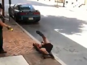 A Pennsylvania police officer is seen on video using a stun gun on a man as he’s sitting on a curb. (Facebook)