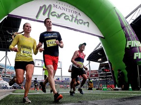 Participants of the 2017 Manitoba Marathon cross the finish line at Investors Group Field in Winnipeg.