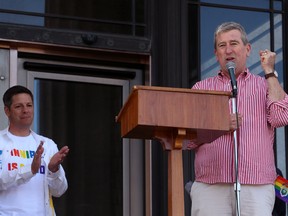 Mayor Brian Bowman (left) applauds while former mayor Glen Murray speaks during the Pride Day rally on the Manitoba Legislative Building grounds on Sunday.