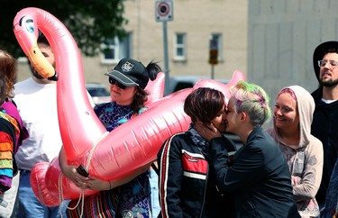 A couple embraces along the parade route during the Pride Day parade on York Avenue in Winnipeg on Sun., June 3, 2018. Kevin King/Winnipeg Sun/Postmedia Network