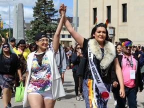 Parade marshall Brielle Beardy-Linklater (right) marches during the Pride Winnipeg Parade on York Avenue on Sunday.