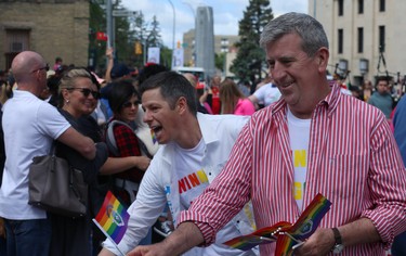 Mayor Brian Bowman (left) and former mayor Glen Murray hand out flags during the Pride Day parade on York Avenue in Winnipeg on Sun., June 3, 2018. Kevin King/Winnipeg Sun/Postmedia Network