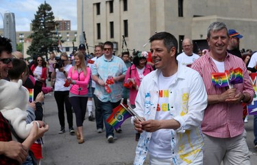 Mayor Brian Bowman (left) and former mayor Glen Murray hand out flags during the Pride Day parade on York Avenue in Winnipeg on Sun., June 3, 2018. Kevin King/Winnipeg Sun/Postmedia Network