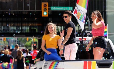 People wave from a float from the Queen City Pride Festival in Regina during the Pride Day parade on York Avenue in Winnipeg on Sun., June 3, 2018. Kevin King/Winnipeg Sun/Postmedia Network