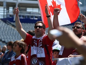 Members of support club Red River Rising cheer during the unveiling of Valour FC, Winnipeg's professional soccer team to begin play in spring 2019, at Investors Group Field in Winnipeg on June 6. Nearly 1,100 people have already put down deposits for soccer season tickets.