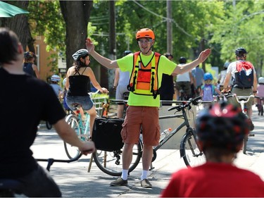 A volunteer directs traffic on Wolseley Avenue during the Fam Jam Wheel Jam in Winnipeg on Sun., June 10, 2018. Kevin King/Winnipeg Sun/Postmedia Network