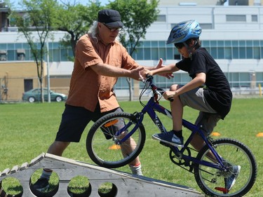 Bike Winnipeg executive director Mark Cohoe helps a rider on the obstacle course at Mulvey School during the Fam Jam Wheel Jam in Winnipeg on Sun., June 10, 2018. Kevin King/Winnipeg Sun/Postmedia Network