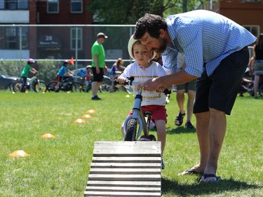 Event coordinator Chris Beauvilain helps Rio German Lodge, 4, on an obstacle course at Mulvey School during the Fam Jam Wheel Jam in Winnipeg on Sun., June 10, 2018. Kevin King/Winnipeg Sun/Postmedia Network