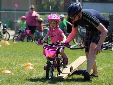 Todd White helps daughter Mackenzie, 5, over an obstacle at Mulvey School during the Fam Jam Wheel Jam in Winnipeg on Sun., June 10, 2018. Kevin King/Winnipeg Sun/Postmedia Network