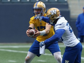 Chris Streveler hands the ball to Johnny Augustine during Winnipeg Blue Bombers practice on Monday.