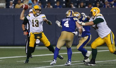 Edmonton Eskimos QB Mike Reilly throws under pressure from Winnipeg Blue Bombers LB Adam Bighill (4) and DE Tristan Okpalaugo during CFL action in Winnipeg on Thurs., June 14, 2018. Kevin King/Winnipeg Sun/Postmedia Network