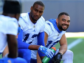 Nic Demski (right) enjoys himself on the sideline with Adarius Bowman (centre) and others during Winnipeg Blue Bombers practice on Monday.