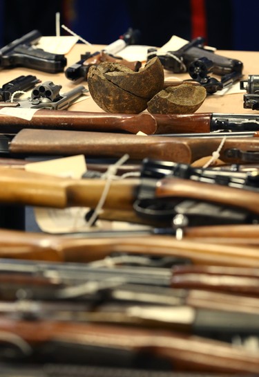 Some of the weapons turned in so far during the 2018 Manitoba Gun Amnesty initiative, including a 9-pound cannonball recovered by a citizen visiting York Factory in 1966, are displayed at Winnipeg police headquarters on Smith Street on Thurs., June 21, 2018. Kevin King/Winnipeg Sun/Postmedia Network