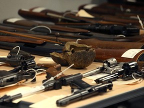 Some of the weapons turned in so far during the 2018 Manitoba Gun Amnesty initiative, including a 9-pound cannonball recovered by a citizen visiting York Factory in 1966, are displayed at Winnipeg police headquarters on Smith Street on Thurs., June 21, 2018. Kevin King/Winnipeg Sun/Postmedia Network