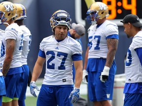 Kienan LaFrance (27) chats with Andrew Harris (right) during Winnipeg Blue Bombers practice on Monday.