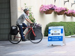 Winnipeg city council candidate Josh Brandon rides away from the city hall on his bike after registering as candidate for the Daniel McIntyre ward on June 30, 2018. Winnipeggers go to the polls for mayor, council and school boards on Oct. 24.