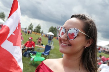 The refection of the Canadian Flag is seen in the sunglasses of Tiana Beaudry moments before she sings O Canada during the Canada Day celebrations at the Sunova Centre in the RM of West St. Paul, Man., north of Winnipeg, Man., on Sunday, July 1, 2018. (Brook Jones/Selkirk Journal/Postmedia Network)