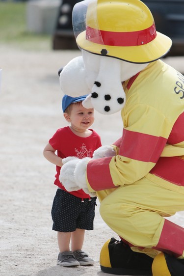 Two-year-old Silas Shaivchuk meets the fire department mascot, Sparky, on Canada Day at the celebrations at the Royal Canadian Legion Branch No. 215 in the RM of East St. Paul just north of Winnipeg, Man., on Sunday, July 1, 2018. (Brook Jones/Selkirk Journal/Postmedia Network)