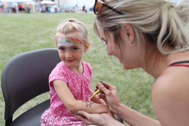 Jo Tawkin draws a henna tattoo on the arm of three-year-old Madelyn Amini during the Canada Day celebrations at the Royal Canadian Legion Branch No. 215 in the RM of East St. Paul, Man., north of Winnipeg, Man., on Sunday, July 1, 2018. (Brook Jones/Selkirk Journal/Postmedia Network)