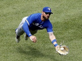 Toronto Blue Jays center fielder Kevin Pillar makes a diving catch on Boston Red Sox's Brock Holt during the third inning of a baseball game Saturday, July 14, 2018, in Boston.