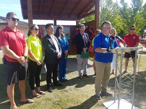 Lifesaving Society – Mb Branch Acting CEO Kevin Tordiffe at the podium is flanked (L to R) by two members of the Beach Safety Program at Birds Hill Park, MLA Ron Schuler, Sarah Painter from Stairs Air Ambulance, Doug Eyolfson – MP for Charleswood – St. James – Assiniboia – Headingley, another member of the Beach Safety Program, Sustainable Development Minister Rochelle Squires, and another member of the Beach Safety Patrol. Handout.