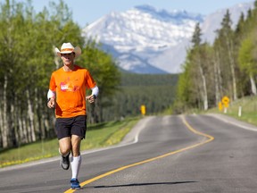 Albertan Dave Proctor, who is raising money for rare disease research, halted his run east of Winnipeg where a sign marks the longitudinal centre of the country.